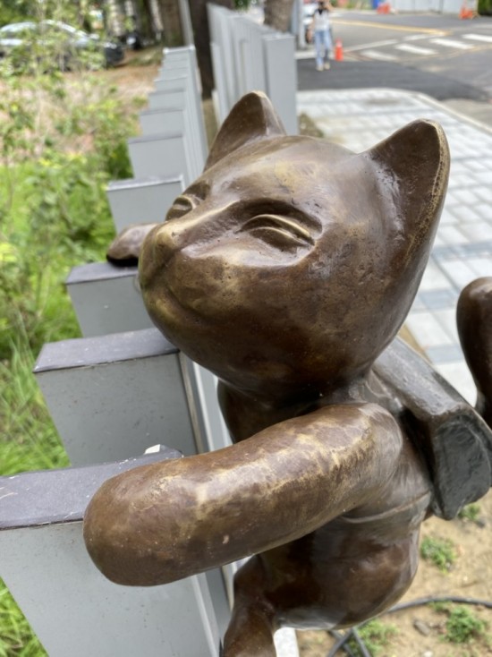 半夢(mèng)半醒的貓咪攀牆上學(xué)，摹寫著孩童們匆忙上學(xué)的日常，藝術(shù)家─曾永玲發(fā)揮天馬行空的想像投設(shè)其中。