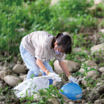 在卵礫石堆中藍(lán)色醒目的「皮球」，吸引了小朋友前去查看並拾起，一點(diǎn)一滴還給河川乾淨(jìng)的面貌。