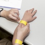 活動開始之前，工作人員協(xié)助大、小朋友們戴上分組的幸運手環(huán)。