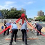 新業(yè)建設 穆椿松名譽董事長(右一)帶領新業(yè)團隊以金鏟鏟起沙堆，象徵工程進度順利，動土開工大吉大利！