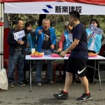 現(xiàn)場新業(yè)建設(shè)穆椿松名譽董事長（左二）與卓勝隆董事長（左一）引領(lǐng)大家，加油吶喊給予跑者支持。