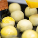 刷上蛋黃液，點(diǎn)上芝麻裝飾，圓潤蓬鬆的蛋黃酥即將穿上金黃酥脆的外衣。