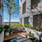 四季合院，每三層設(shè)計一處公共大露臺，從梯廳走入彷彿大家庭的合院(埕)，提供住戶們休憩及交誼空間，搭配四季主題的呼應，此為七樓的夏季-種植小花紫薇與厚葉石斑木。