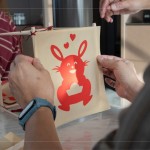 剛完成的剪紙，辛卯喜兔浮躍紙上，手捧著元寶寓意財(cái)源滾滾，家族發(fā)揮創(chuàng)意增添
兩顆小愛心，俏皮且生動的趣味十足。