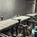 乾燥處理過的磁磚，整齊地陳列在輸送臺上，準(zhǔn)備進(jìn)入下一道逐層施釉的工序。