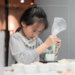 小小雙手緊握擠花袋，細(xì)心為杯子蛋糕擠上糖霜，手作成了最甜的學(xué)習(xí)，悄悄留下屬於成長與節(jié)日的美好回憶。